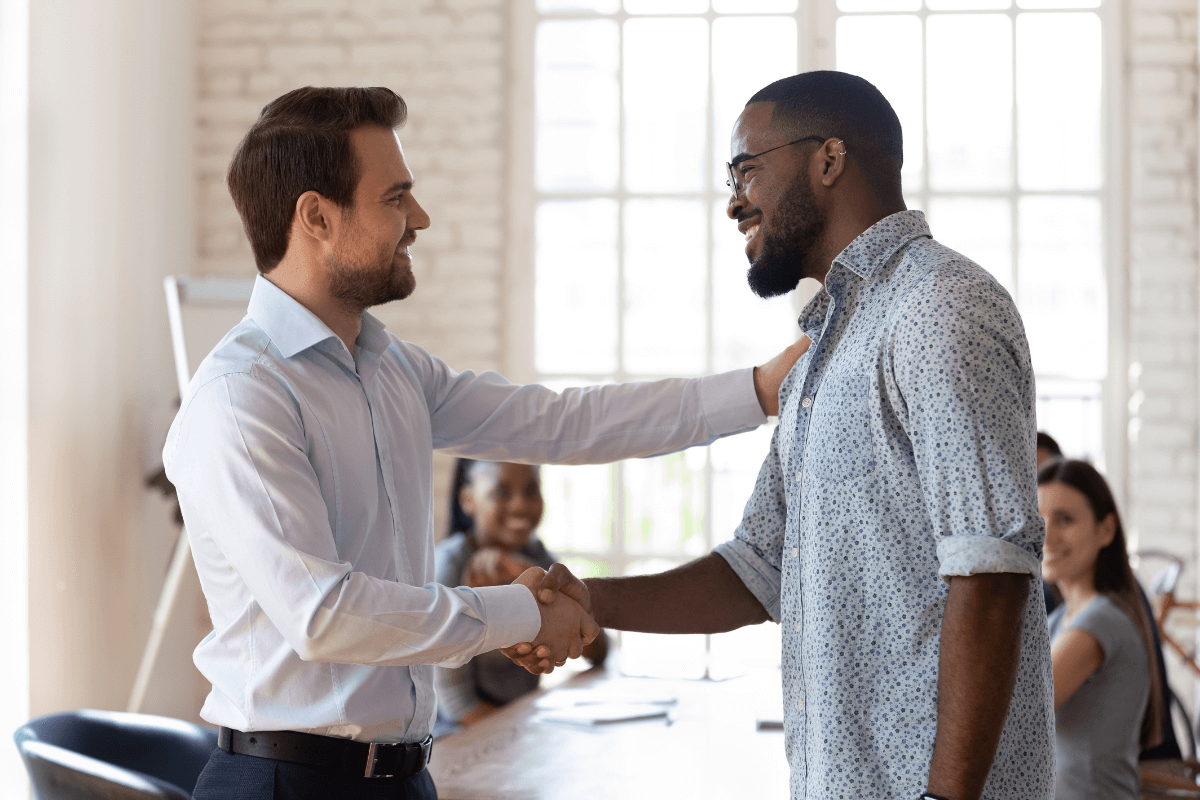 A leader welcomes a new team member to a diverse group